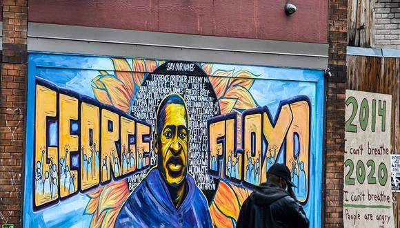 Un hombre pasa junto a un mural de George Floyd en Minneapolis, Minnesota (Estados Unidos), el 10 de marzo de 2021. (CHANDAN KHANNA / AFP).