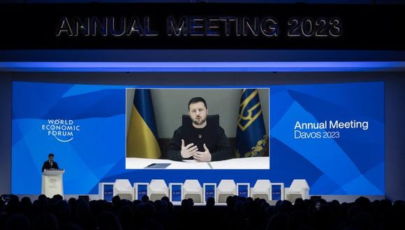 El presidente de Ucrania, Volodymyr Zelensky, se muestra en una pantalla a través de un enlace de video en el centro de congresos durante la reunión anual del Foro Económico Mundial (FEM) en Davos el 18 de enero de 2023. (Foto de Fabrice COFFRINI / AFP)