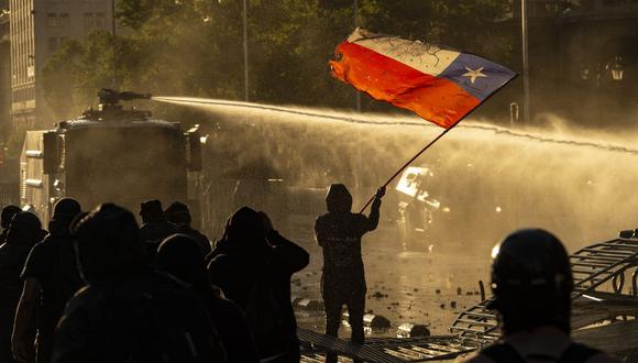 Los manifestantes son rociados por un cañón de agua de la policía antidisturbios durante los enfrentamientos en Santiago de Chile el 27 de noviembre de 2020. (Foto referencial, Martín BERNETTI / AFP).