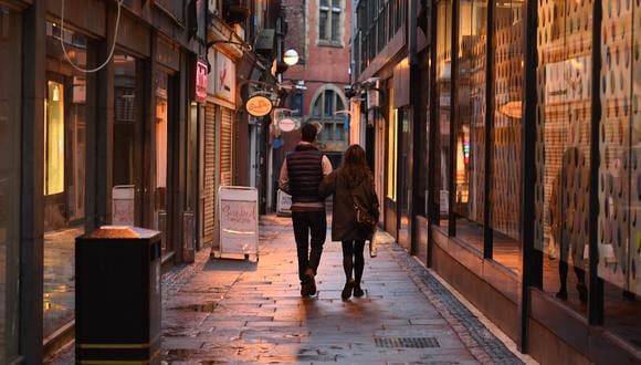 Una pareja pasa frente a tiendas cerradas en el centro de Sheffield, en el norte de Inglaterra, el 21 de octubre de 2020, antes de nuevas medidas para frenar el coronavirus. (Foto de Oli SCARFF / AFP).