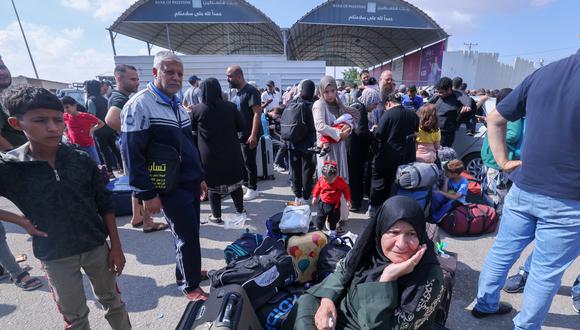 Palestinos, algunos con pasaportes extranjeros que esperan cruzar a Egipto y otros que esperan ayuda, esperan en el cruce de Rafah, en el sur de la Franja de Gaza, el 16 de octubre de 2023. (Foto de Mohammed ABED / AFP)