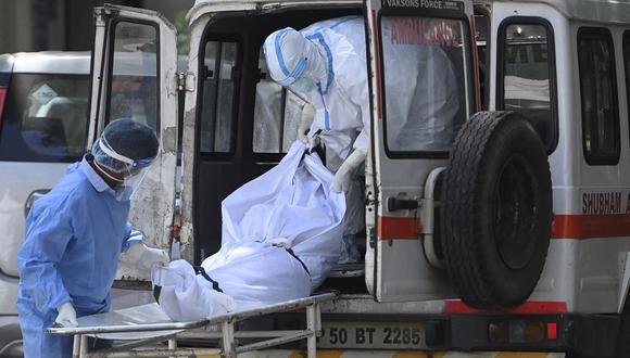 Personal de un hospital saca el cuerpo de una víctima de coronavirus en Nueva Delhi, India. (Foto de Money SHARMA / AFP).