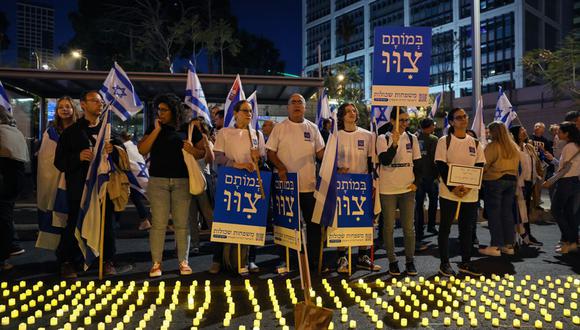 Los manifestantes se paran junto a un rastro de velas durante una manifestación para protestar contra el proyecto de ley de reforma judicial del gobierno israelí en Tel Aviv, el 22 de abril de 2023 (Foto: JACK GUEZ / AFP)