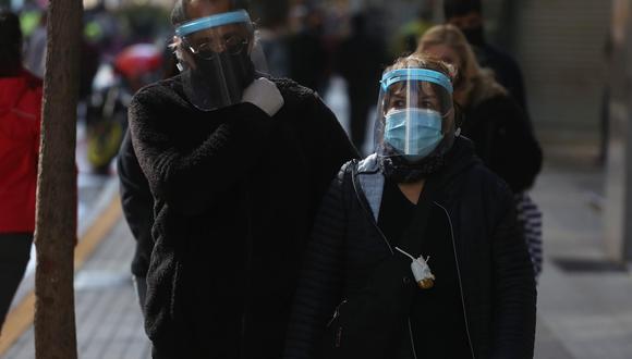 Dos ciudadanos protegidos con mascarilla y careta caminan por el principal corredor peatonal del centro de Santiago (Chile), en una fotografía de archivo. EFE/Elvis González