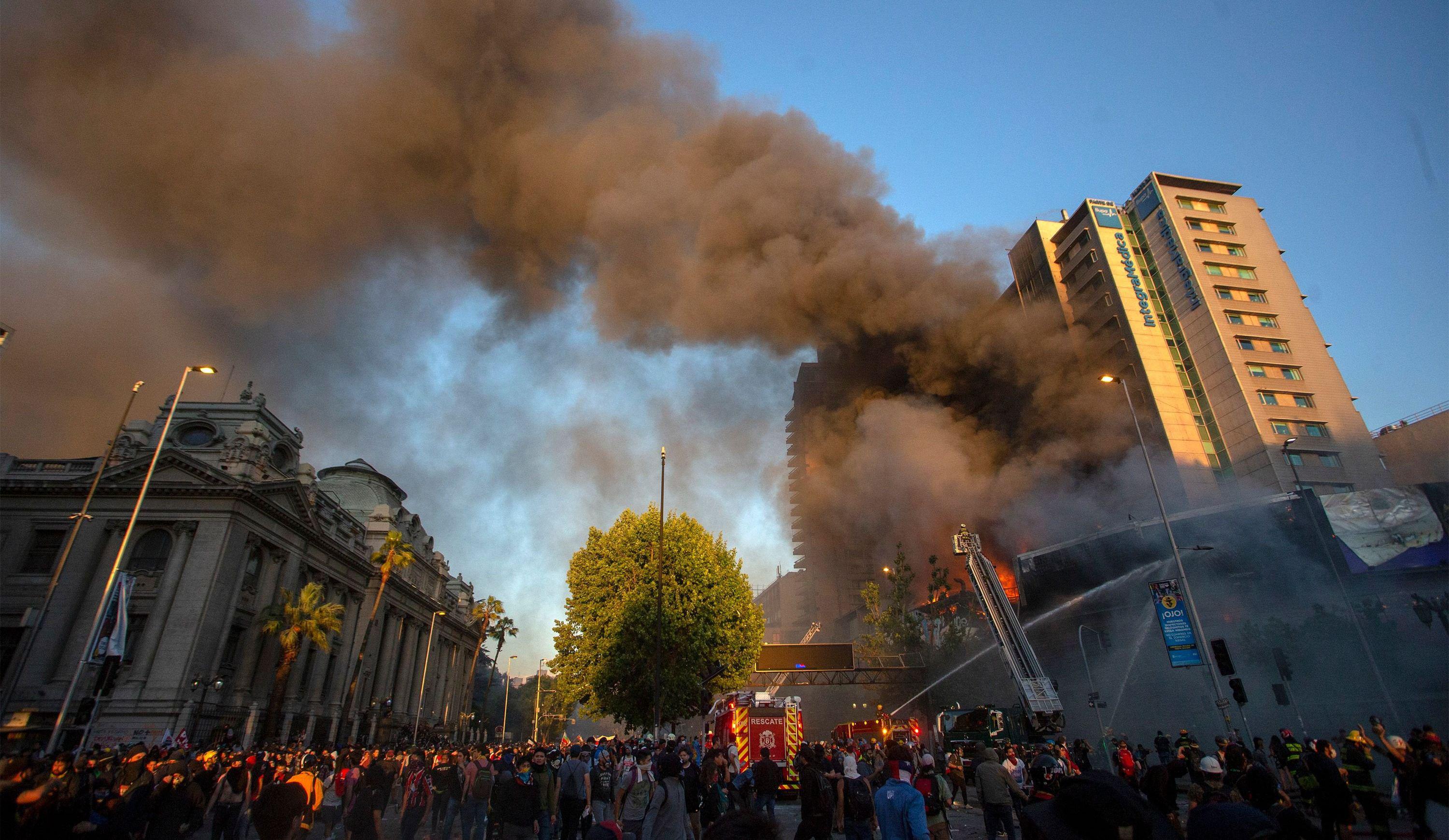 Los bomberos combaten un incendio en un edificio de Santiago. (AFP / Claudio REYES).