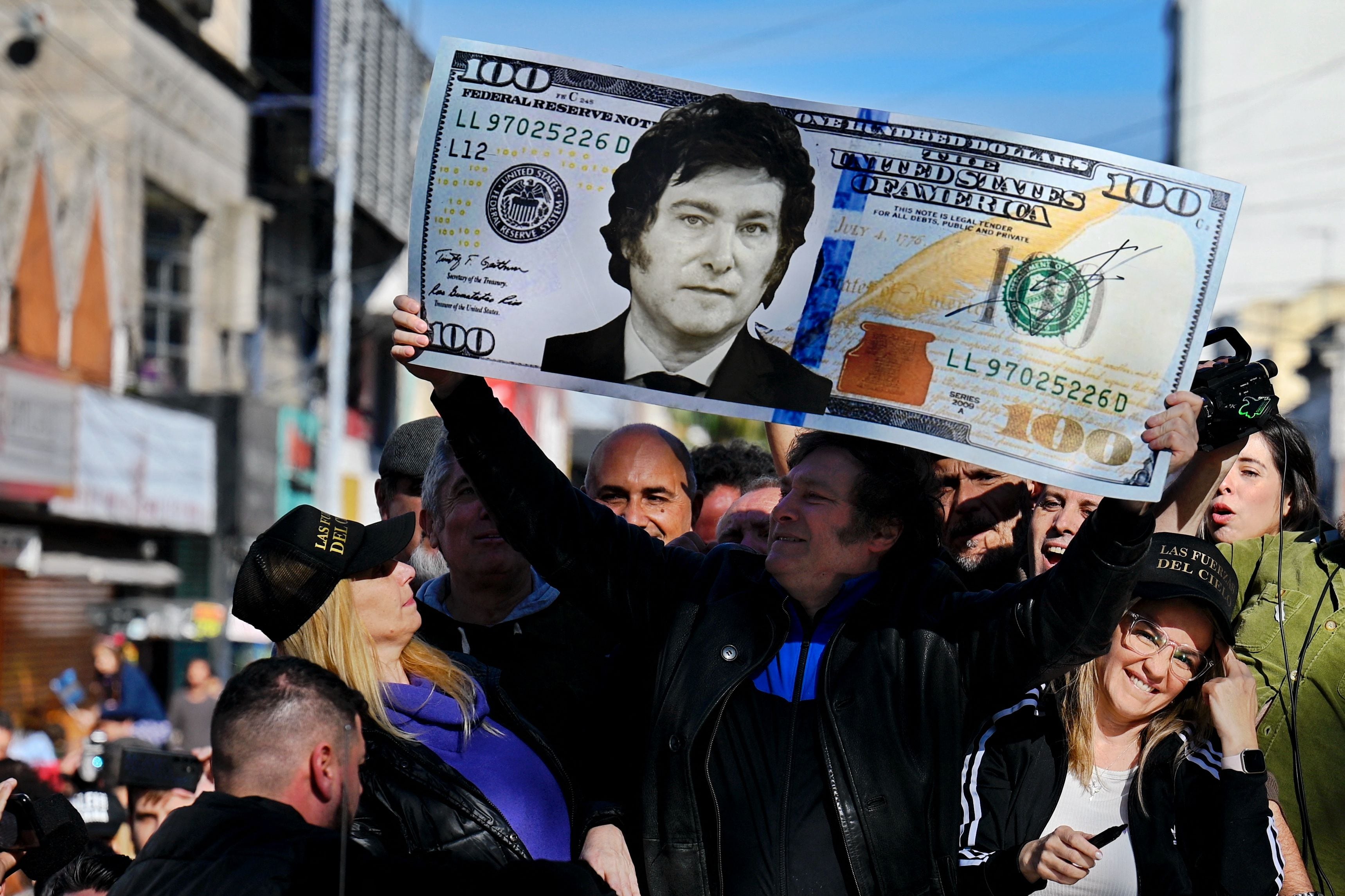 Javier Milei holds a giant US$100 bill with his face during a campaign rally in San Martín, Buenos Aires province, on September 25, 2023. (Photo by Luis ROBAYO/AFP).