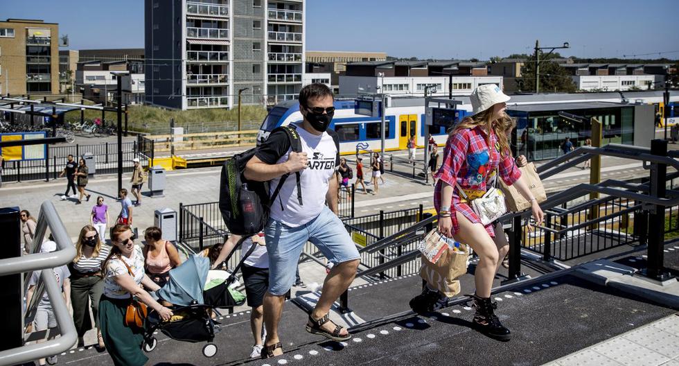 Un grupo de personas caminan en la estación de Zandvoort. Se puede apreciar que algunos utilizan mascarillas para evitar contagiarse del nuevo coronavirus. (Koen Van WEEL / ANP / AFP)