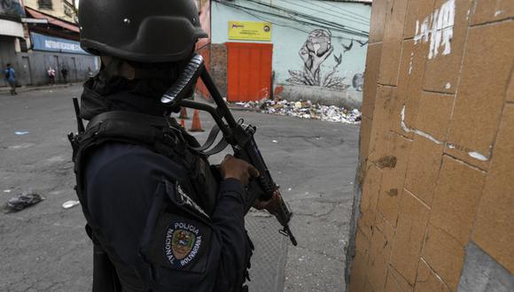 Un miembro de la Policía Nacional Bolivariana monta guardia en una esquina durante un enfrentamiento con presuntas bandas criminales en el barrio La Vega de Caracas el 24 de mayo de 2021. (Foto de Yuri CORTEZ / AFP).