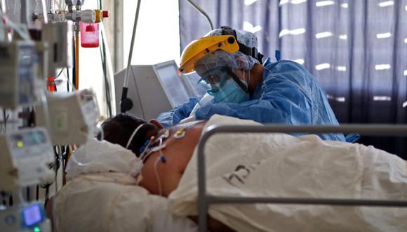 Un trabajador de la salud revisa a un paciente con COVID-19 en la UCI del Hospital San Roque de Córdoba, Argentina. (Foto: AFP / Nicolás Aguilera).