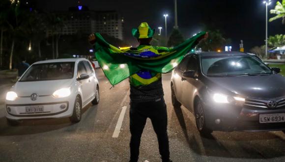Un partidario del presidente brasileño Jair Bolsonaro, que se postula para otro mandato, celebra los resultados parciales tras el cierre de las urnas de las elecciones generales frente a su casa en Río de Janeiro, Brasil, el domingo 2 de octubre de 2022.