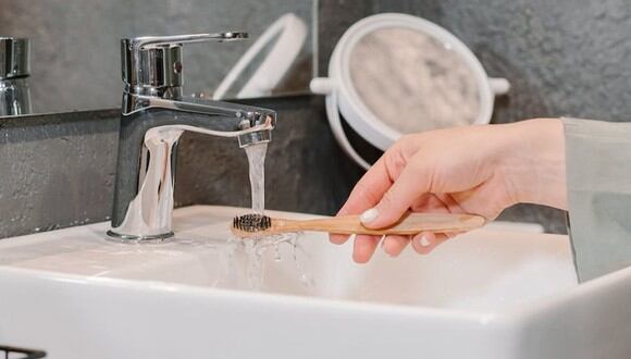Una mujer lavando su cepillo de dientes. | Imagen referencial: Mikhail Nilov / Pexels