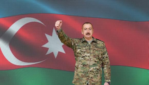 El presidente de Azerbaiyán, Ilham Aliyev, vestido con ropa militar y levantando el puño durante un discurso televisado a la nación. (AFP).