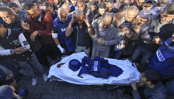 Colegas y familiares rezan sobre el cuerpo del camarógrafo de Al Jazeera, Samer Abu Daqa, quien murió durante el bombardeo israelí, durante su funeral en Khan Yunis, en el sur de la Franja de Gaza, el 16 de diciembre de 2023, en medio de las continuas batallas entre Israel y el grupo militante. Hamás. (Foto de Mahmud HAMS / AFP)