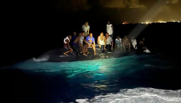 En esta foto proporcionada por la Real Fuerza de Defensa de Bahamas, los sobrevivientes se sientan en un bote volcado cuando están a punto de ser rescatados cerca de New Providence en las Bahamas.