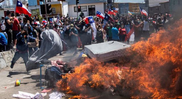 Manifestantes queman un campamento improvisado de migrantes venezolanos durante una marcha de protesta contra la migración ilegal en Iquique, Chile.. (Foto: MARTIN BERNETTI / AFP)