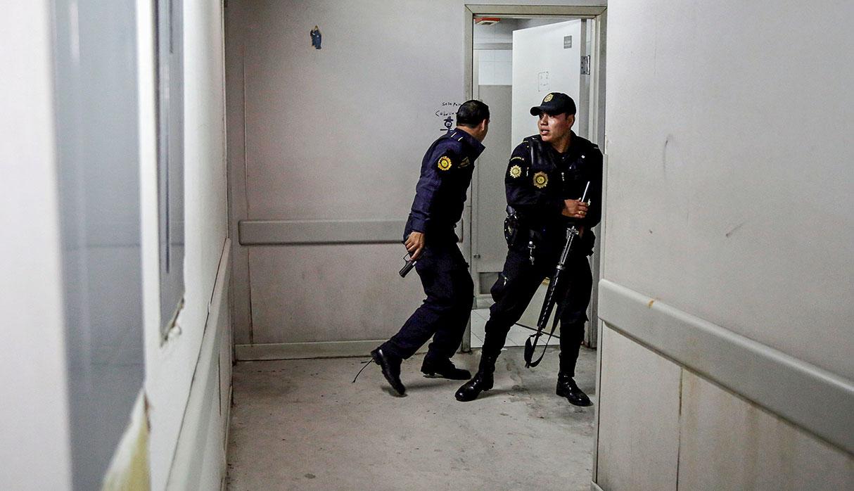 Police officers stand guard after suspected gang members attacked Roosevelt Hospital in Guatemala City, Guatemala August 16, 2017. REUTERS/Luis Echeverria