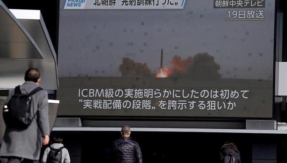 Peatones pasan frente a una pantalla en Tokio el 20 de febrero de 2023, que muestra imágenes del lanzamiento de misiles de Corea del Norte transmitidas por la Televisión Central de Corea el 19 de febrero. (Foto de Kazuhiro NOGI / AFP)