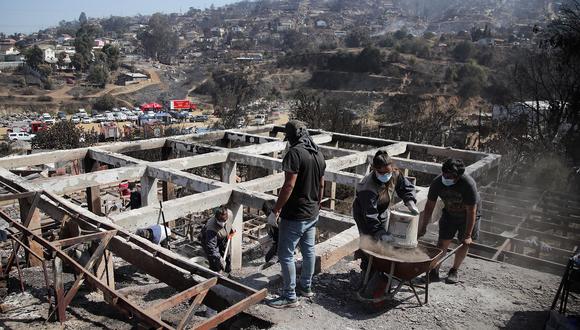 Residentes retiran escombros de casas quemadas tras los incendios forestales en Villa Independencia, Viña del Mar, Chile, el 5 de febrero de 2024. (Foto de Javier TORRES / AFP)