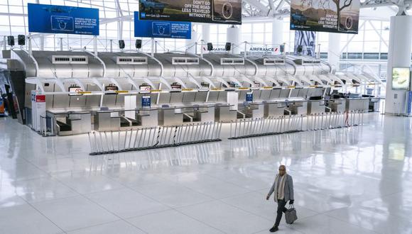 En esta foto de archivo tomada el 12 de marzo de 2020, un hombre pasa frente a los mostradores cerrados de Air France en la sección de la Terminal 1 del Aeropuerto Internacional John F. Kennedy en la ciudad de Nueva York. (Foto de Kena Betancur / AFP)