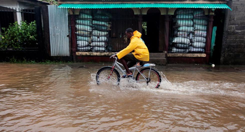 Un residente monta su bicicleta en una calle inundada tras el paso del huracán Julia en la ciudad de Bluefields, en la costa caribeña de Nicaragua, el 9 de octubre de 2022. (OSWALDO RIVAS / AFP).