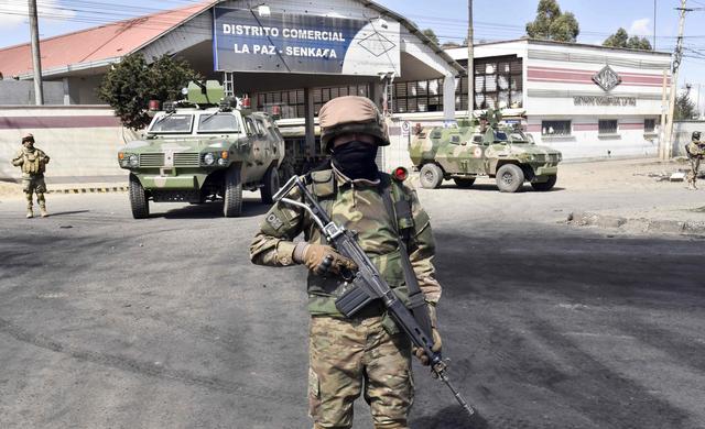 Soldados del Ejército de Bolivia montan guardia en la entrada de la planta de combustible de Senkata, en El Alto. (AFP / AIZAR RALDES).