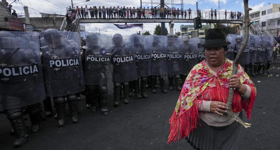 Una mujer se para frente a una línea de policías antidisturbios durante las protestas antigubernamentales convocadas principalmente por organizaciones indígenas, en Quito, Ecuador, el jueves 16 de junio de 2022. (AP Foto/Dolores Ochoa).