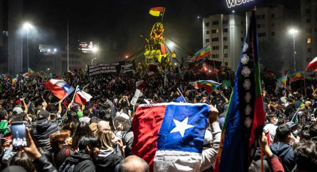 Los manifestantes que apoyan la reforma de la constitución chilena celebran mientras esperan los resultados oficiales del referéndum en la plaza Italia en Santiago. (AFP / Pedro Ugarte).