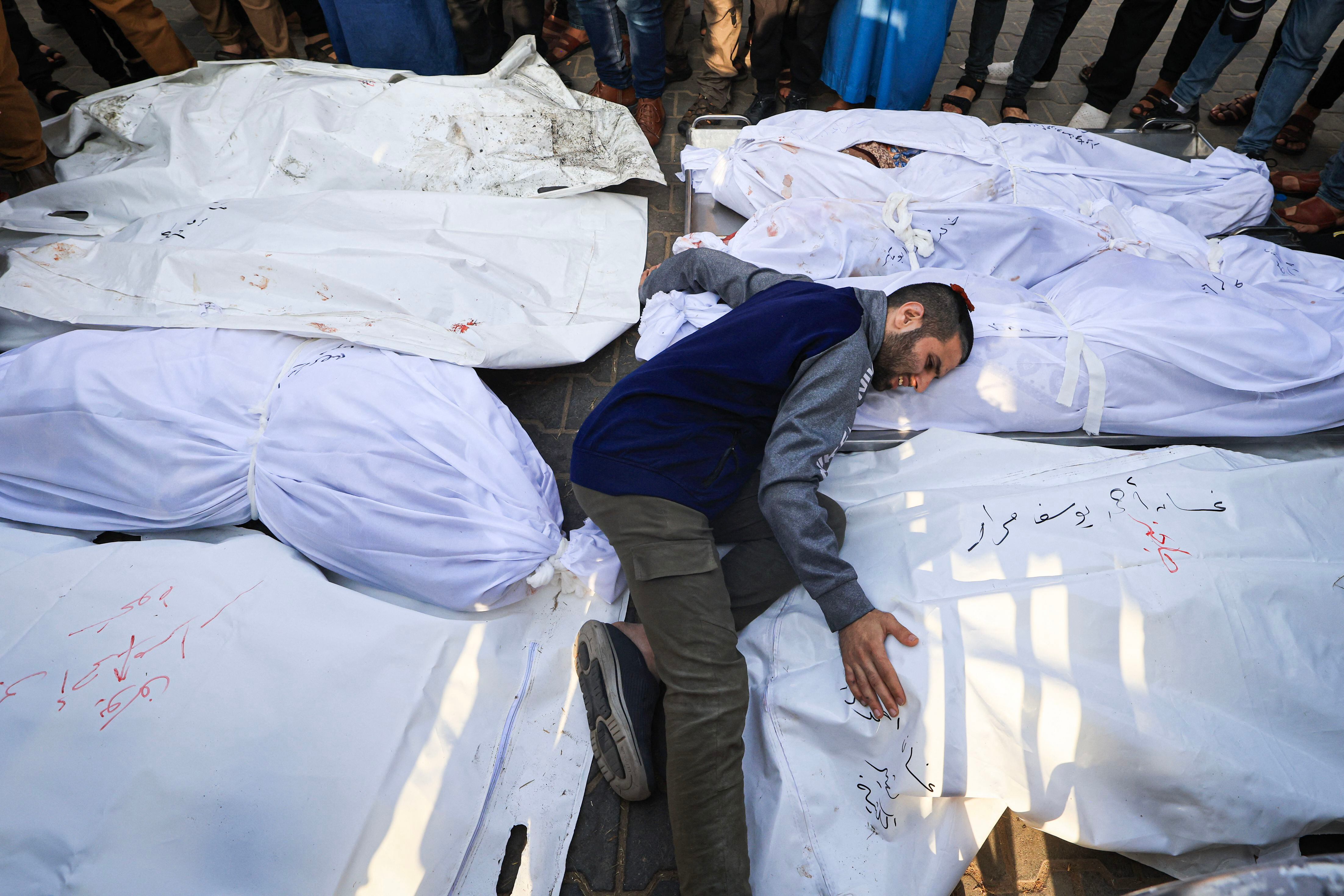 A person cries next to the bodies of members of the Abu Morad family who died after Israeli attacks in Khan Yunis, in the south of the Gaza Strip, on October 24, 2023. (Photo by Mahmud HAMS/AFP).
