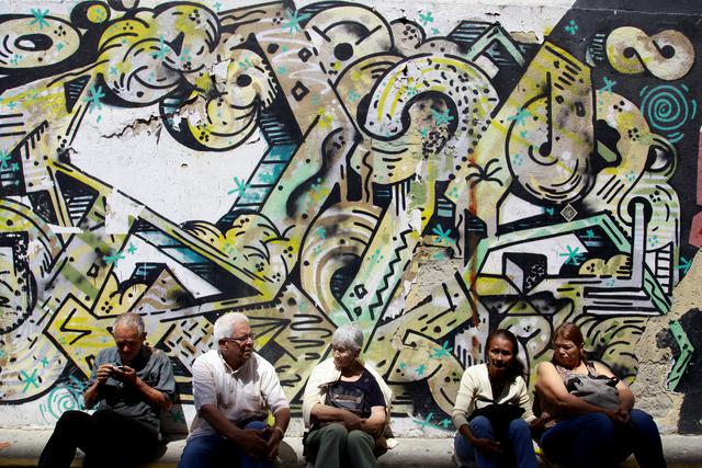 FOTO 6 | Ancianos esperando en las aceras de una calle en Caracas. (Foto: Reuters)