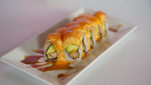 The Ohashi Roll is stuffed with breaded shrimp and avocado, and covered with flamed salmon in a slightly sweet sauce and togarashi.