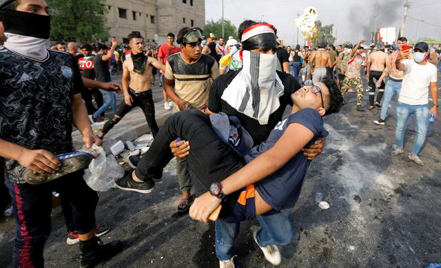 Un hombre carga a un manifestante, herido durante una protesta por el desempleo, la corrupción y los servicios públicos deficientes, en Bagdad, capital de Irak. (REUTERS / Khalid al-Mousily).