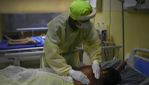 Un trabajador de la salud le da palmaditas en la espalda a un paciente con COVID-19 en la unidad de cuidados intensivos del Hospital público Ana Francisca Pérez de León II en Caracas, Venezuela. (Foto: AP / Matias Delacroix).