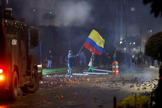 Integrantes del Escuadrón Móvil Antidisturbios (ESMAD) se enfrentan a manifestantes que llegan al barrio donde tiene su residencia el presidente de Colombia Iván Duque. (EFE/Mauricio Dueñas Castañeda).