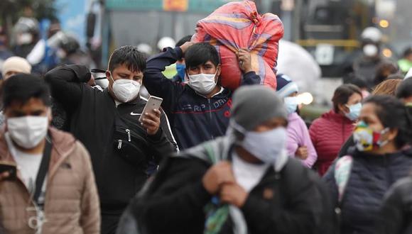 Vendedores ambulantes se desplazan luego de ser desalojados por la policía de una vía pública donde trabajaban en Lima, Perú, país seriamente golpeado por la pandemia de coronavirus. (EFE/Paolo Aguilar).