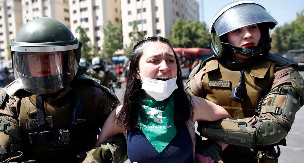La policía detiene a una mujer durante una protesta en el centro de Santiago. (AFP / Pablo VERA).