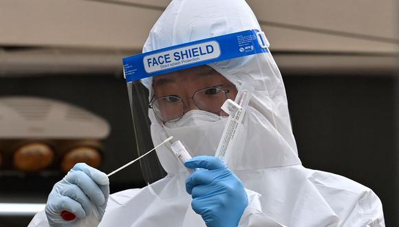 Un miembro del personal médico que usa equipo de protección hace una prueba de coronavirus afuera del Ayuntamiento de Seúl, Corea del Sur, el 28 de diciembre de 2020. (Jung Yeon-je / AFP).