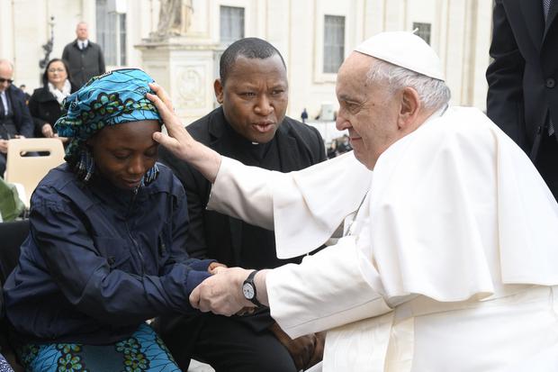 Papa Francisco bendiciendo a Janada Marcus, una joven nigeriana víctima del grupo islamista Boko Haram, durante la audiencia general semanal el 8 de marzo de 2023 en la plaza de San Pedro en el Vaticano. (Photo by Handout / VATICAN MEDIA / AFP)