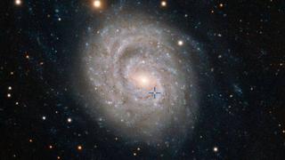 Descubren una galaxia espiral junto a una supernova brillante