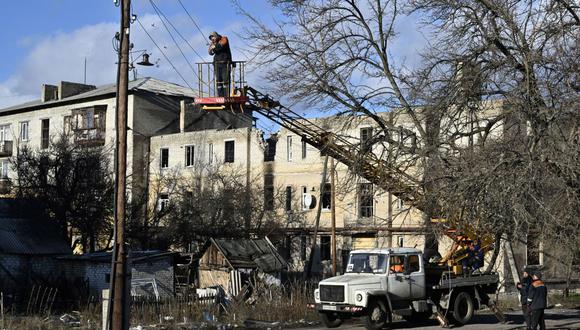 Los trabajadores reparan las líneas eléctricas en la ciudad de Lyman, región de Donetsk, el 14 de diciembre de 2022, en medio de la invasión rusa de Ucrania. (Foto de Genya SAVILOV / AFP)