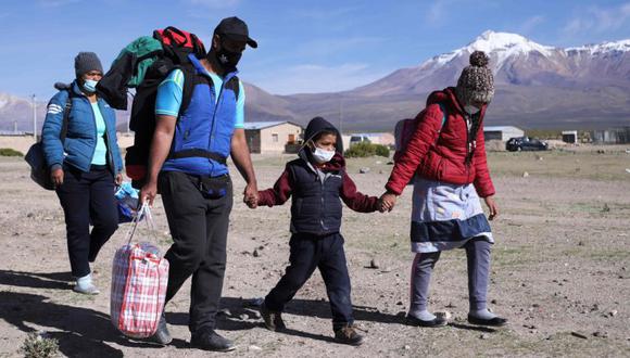 Una familia migrante venezolana es vista después de cruzar ilegalmente la frontera entre Bolivia y Chile en Colchane, Chile. (Foto Referencial: AFP / IGNACIO MUNOZ).