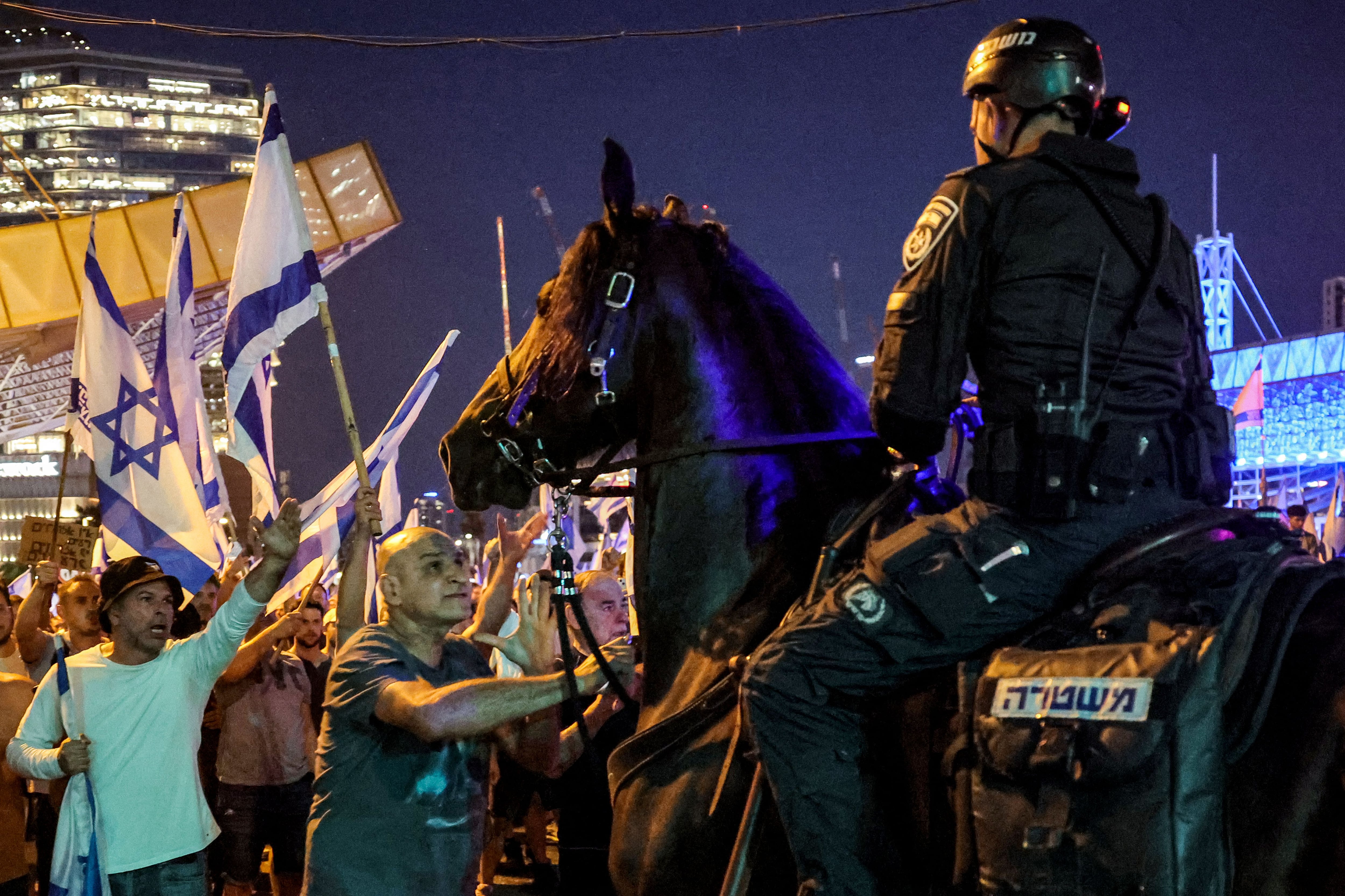 Israeli mounted riot police confront protesters during a protest rally against the Israeli government's judicial reform plan in Tel Aviv on July 24, 2023.(Photo by JACK GUEZ/AFP)
