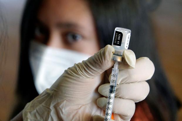 Health personnel prepare a dose of the Pfizer / BioNTech vaccine against the COVID-19 coronavirus in a private school in Quito on September 13, 2021. (RODRIGO BUENDIA / AFP).