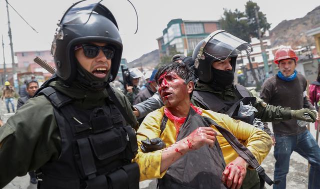 Miembros de las fuerzas de seguridad detienen a un hombre herido durante enfrentamientos entre partidarios de Evo Morales y partidarios de la oposición en La Paz. (REUTERS / Carlos Garcia Rawlins).