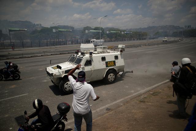 El momento en que una tanqueta militar arrolla a manifestantes en Caracas. Foto: Reuters