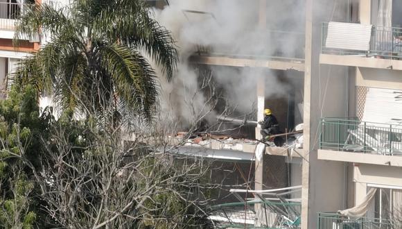 Un bombero apaga un incendio en un edificio residencial que resultó dañado por una explosión, en Montevideo, Uruguay.