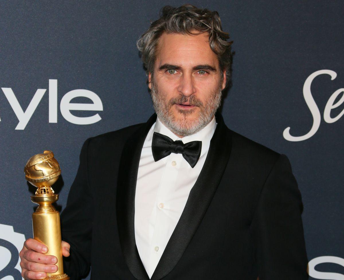 Joaquin Phoenix posa junto a su premio en los Globos de Oro. (Foto: AFP)