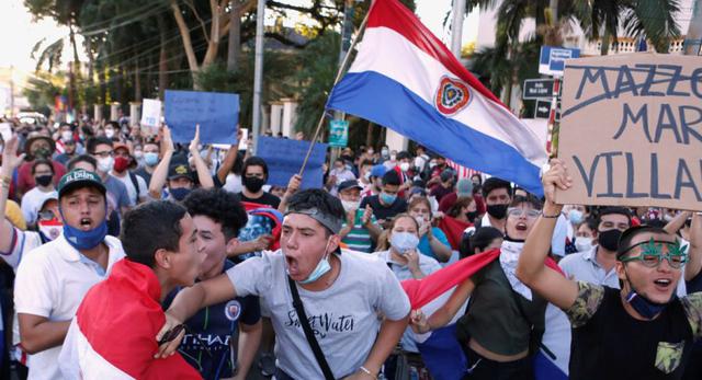Paraguayos protestan contra las políticas de salud del presidente Mario Abdo Benítez y la falta de vacunas contra el coronavirus (COVID-19) cerca de la residencia presidencial Mburuvicha Roga en Asunción, Paraguay. (Foto: REUTERS / Cesar Olmedo).