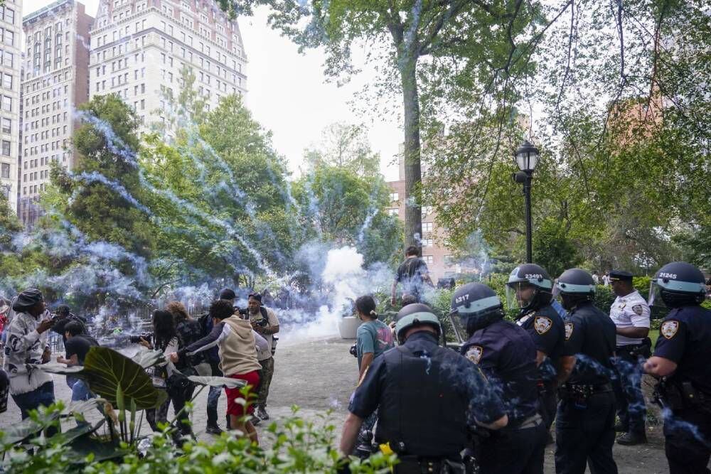 Police detonate a smoke bomb to disperse a crowd.  (Photo: Mari Altaffer/AP)
