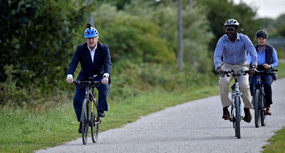 Boris Johnson (izq.) y el diputado conservador por Broxtowe Darren Henry manejan bicicleta en el Canal en Beeston, centro de Inglaterra. (Foto: Rui Vieira / POOL / AFP).