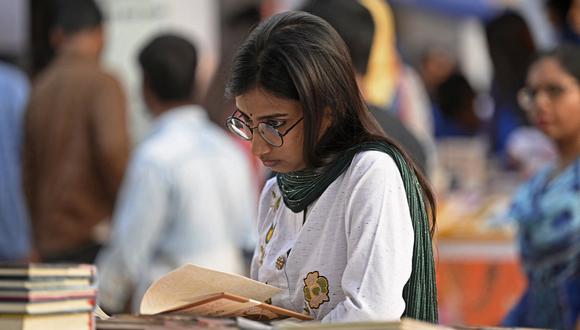 Un visitante lee un libro en la feria nacional del libro en Dhaka el 5 de febrero de 2023. (Foto referencial de Munir uz zaman / AFP)